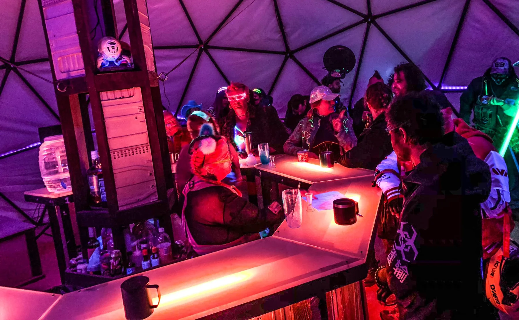 Guests talking around the illuminated bar inside the bay